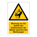 Warnung vor der Gefahr des Einklemmens der Hände zwischen den Werkzeugen